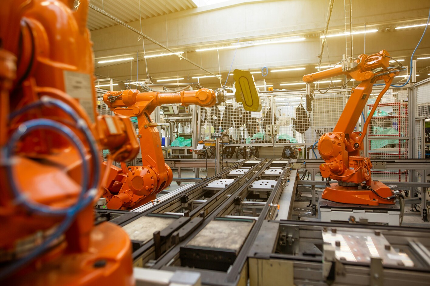 factory with orange machines and a grey conveyer belt